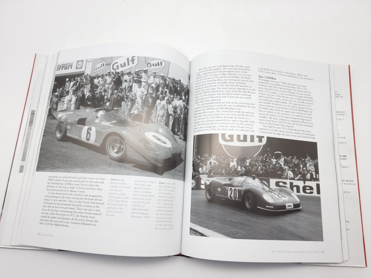 Open automotive history book showing race car photos with crowd scenes and captions