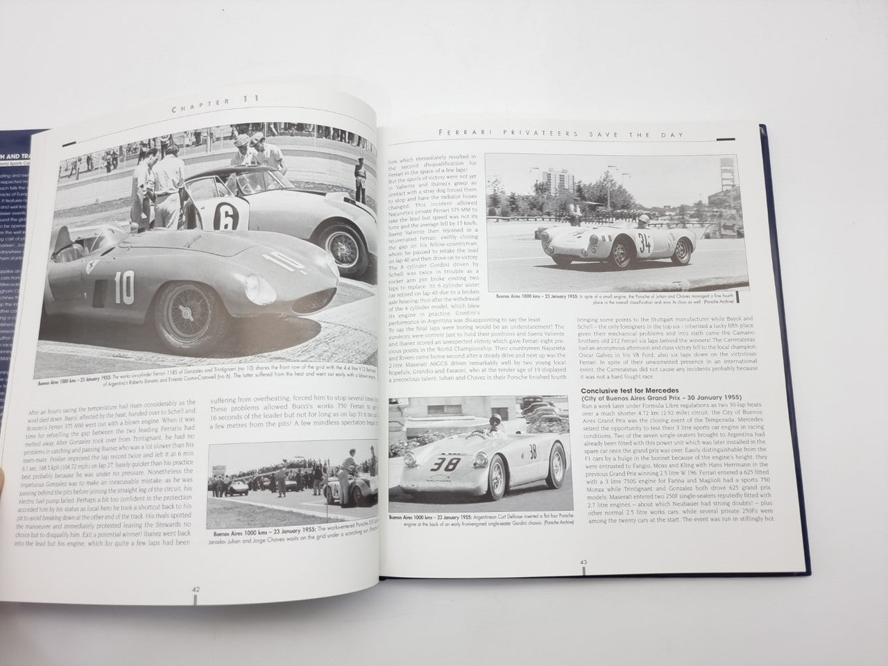 Open photo book spread with vintage sports car images and dense text columns