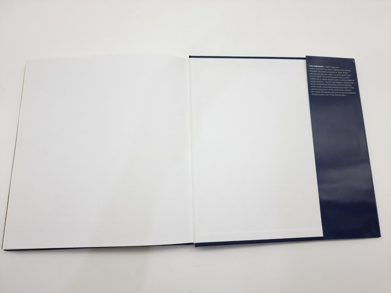 Open photo book with blank pages and a blue back-cover panel