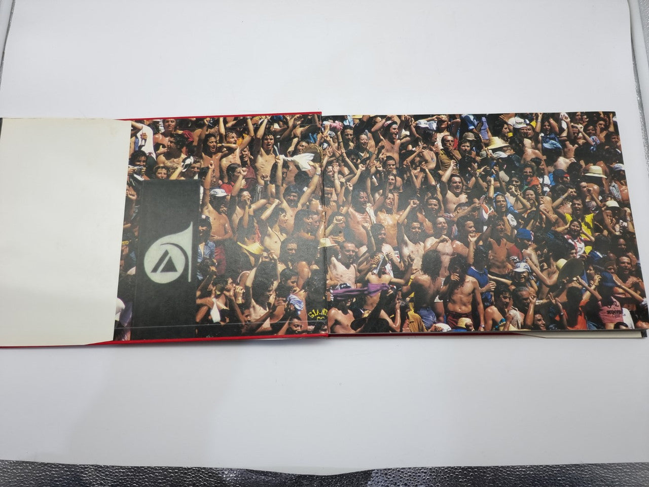 Hardcover book open to crowd photo spread with racing-themed visuals