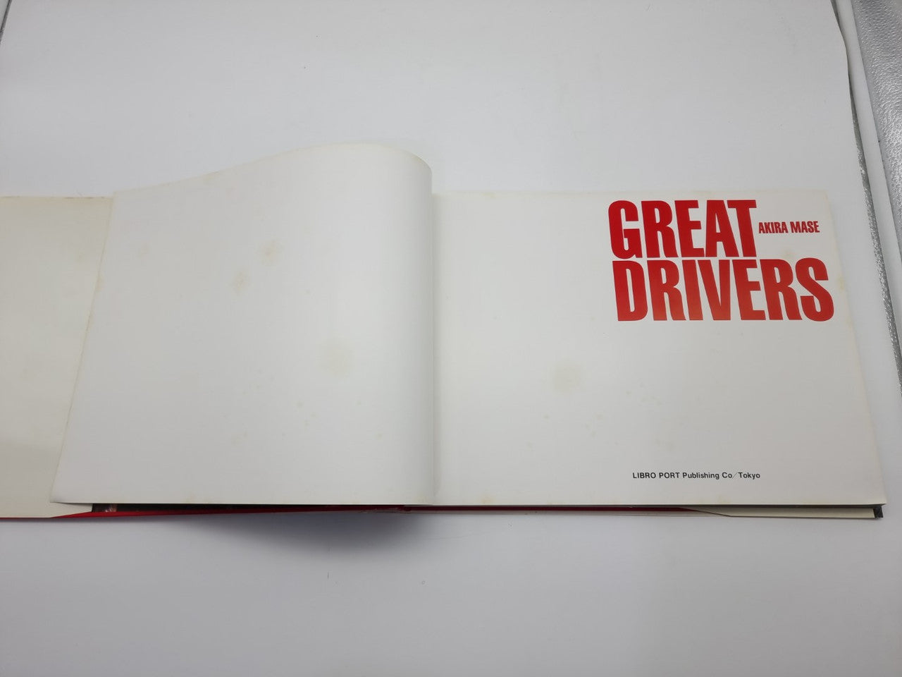 Hardcover book open to page with 'GREAT DRIVERS' red title logo