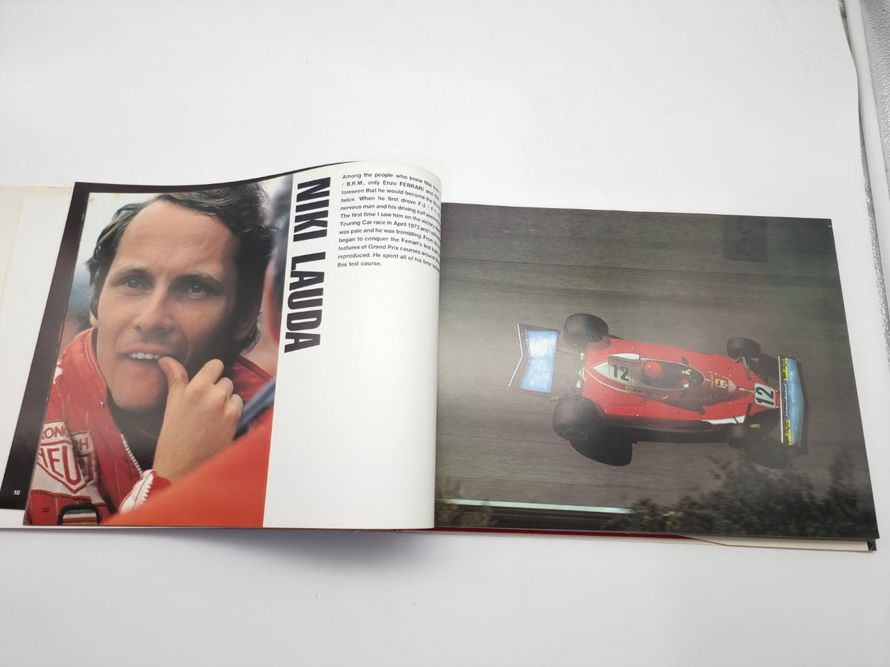 Hardcover book open to driver portrait and red racing car photo spread