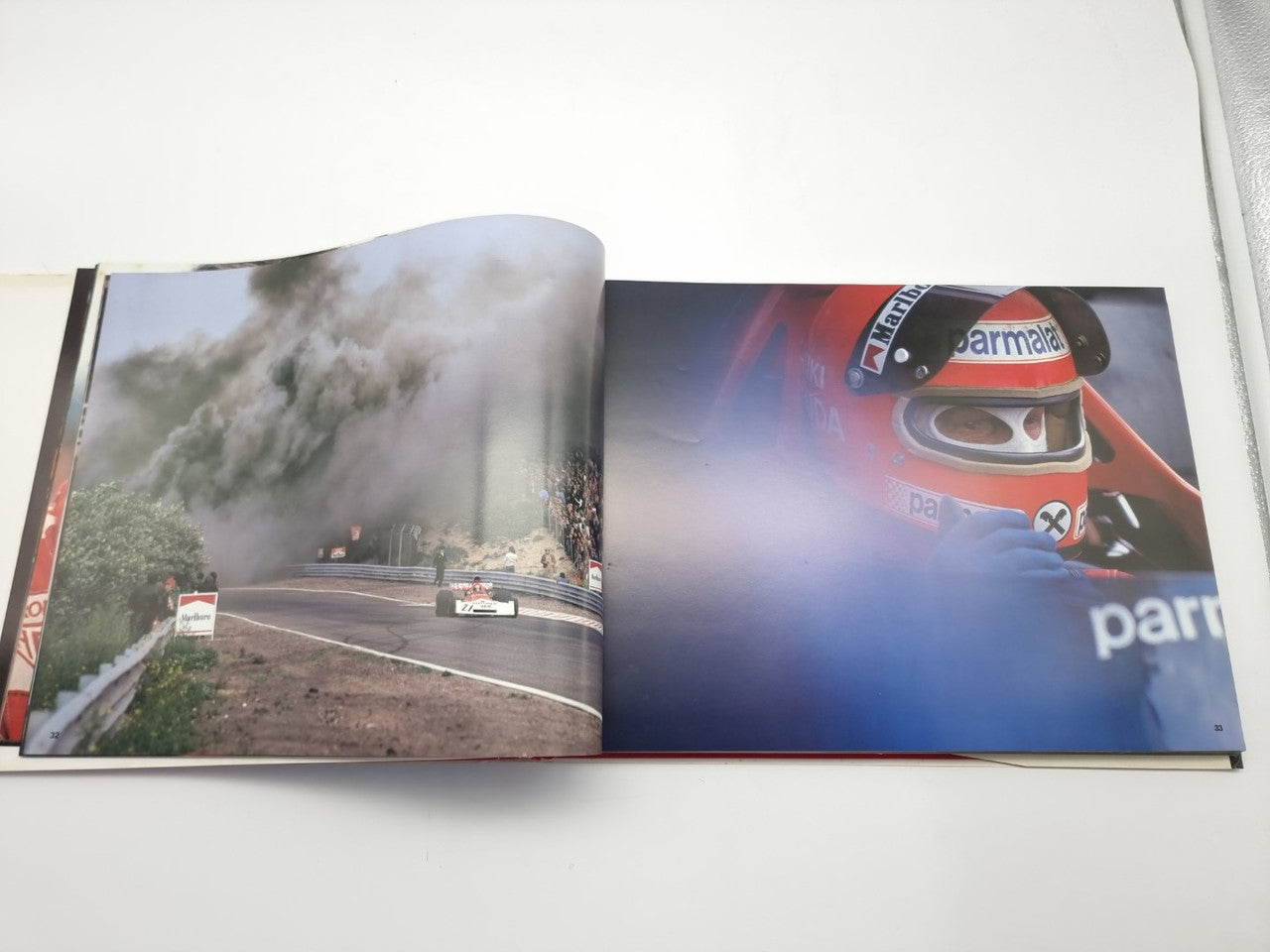 Hardcover book open to track landscape photo and red car close-up spread