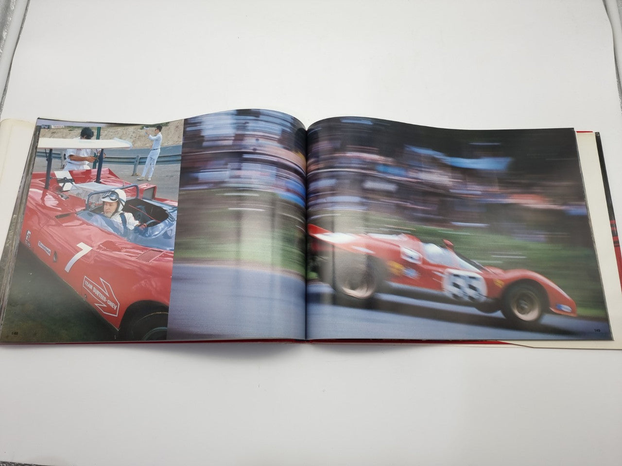 Open motorsport photo book with red race car and driver portrait across two pages