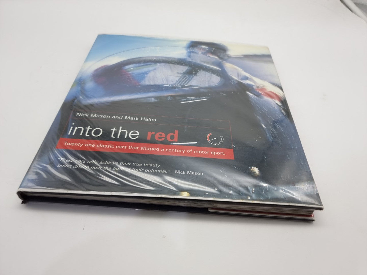 Signed motorsport history hardcover book with blue car cover and red title text