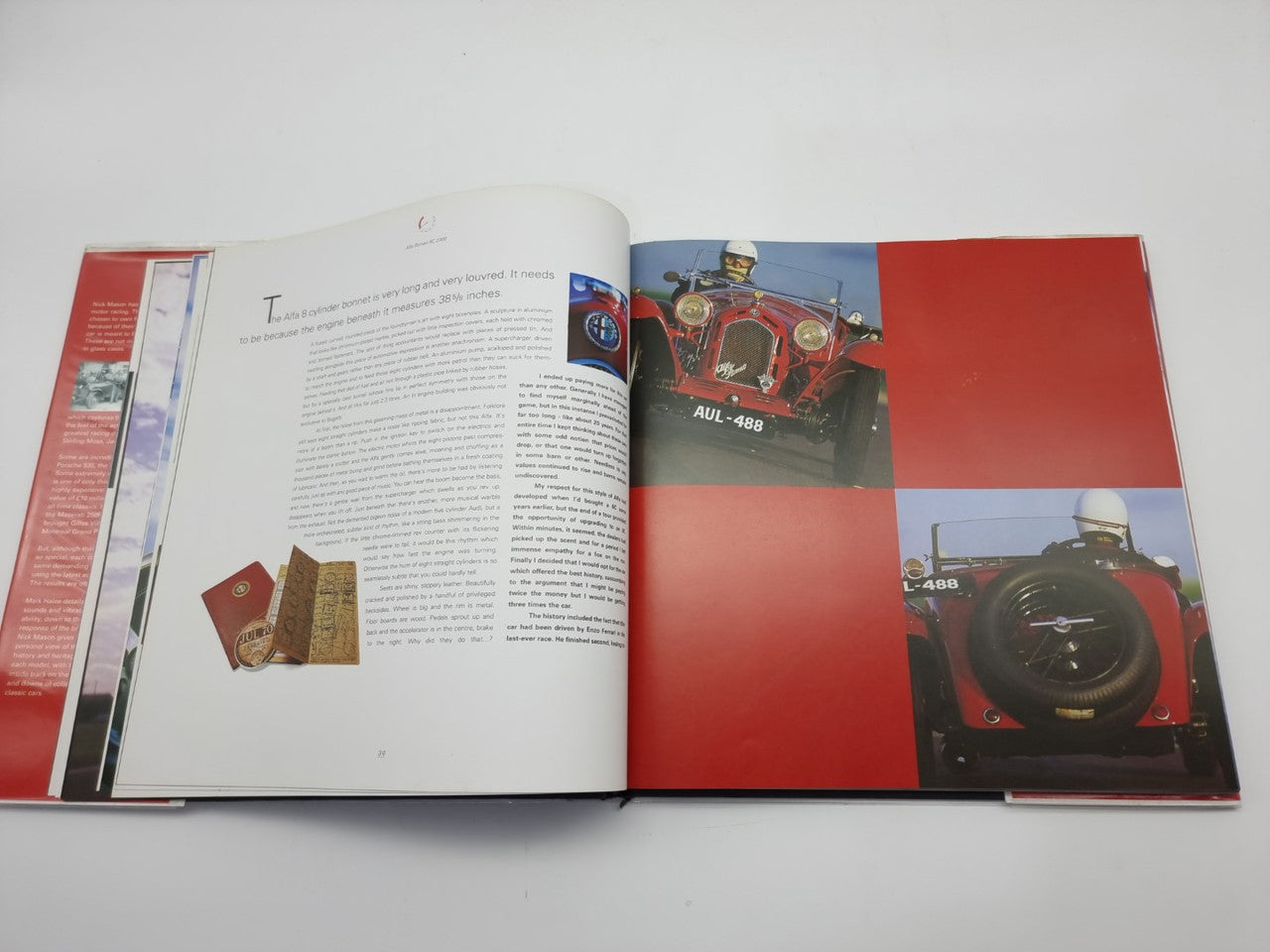 Open motorsport history book spread with car photo and red graphic panels