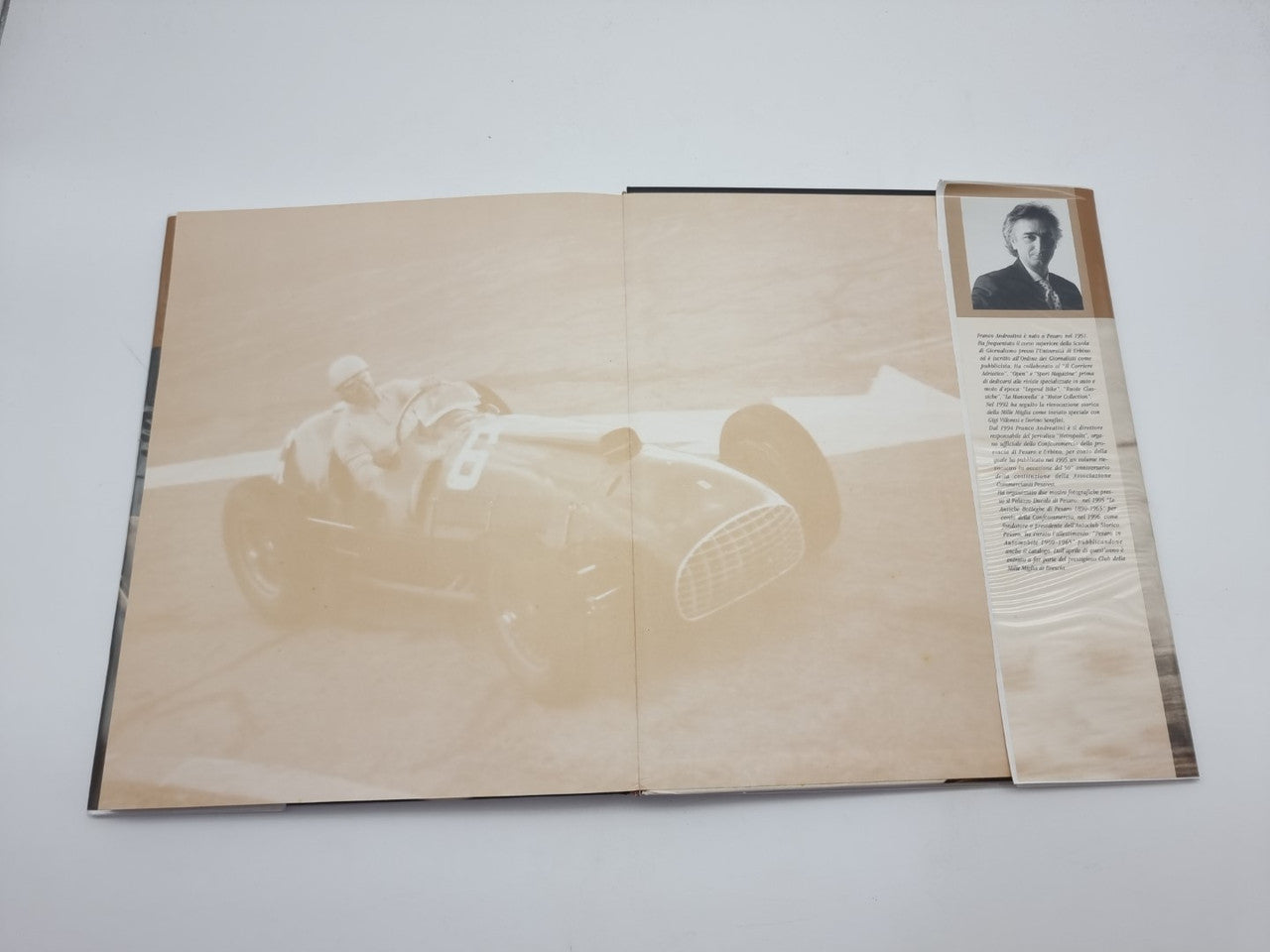 Opened hardcover photo book with sepia spread image and portrait thumbnail on right page