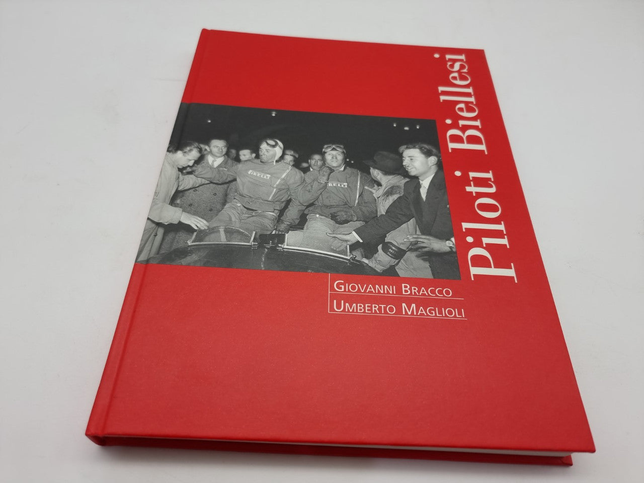 Red hardcover book with black-and-white group photo band and white author names.