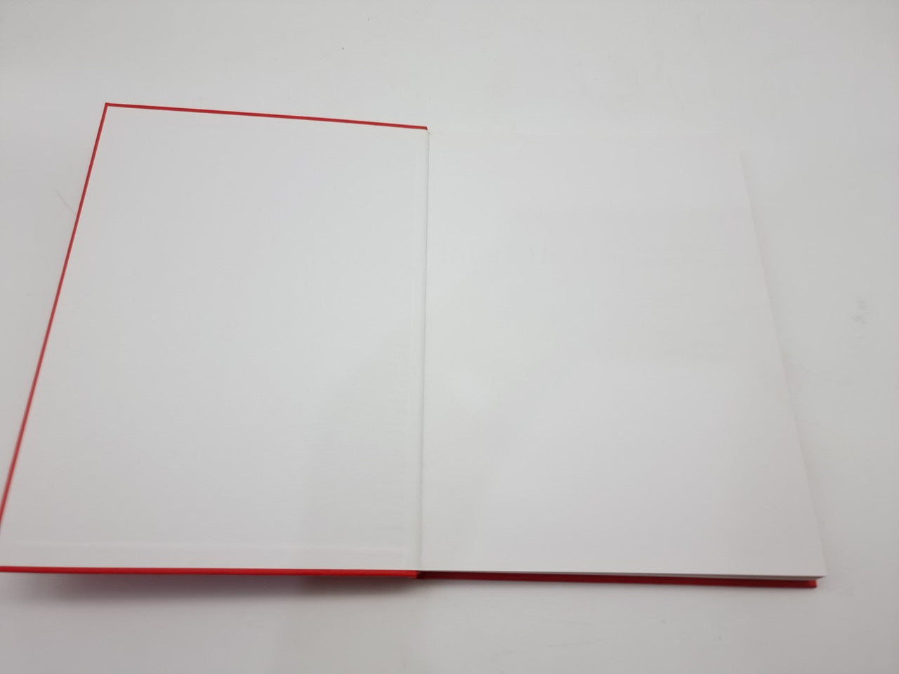 Open book with red-edged pages and blank white spreads.
