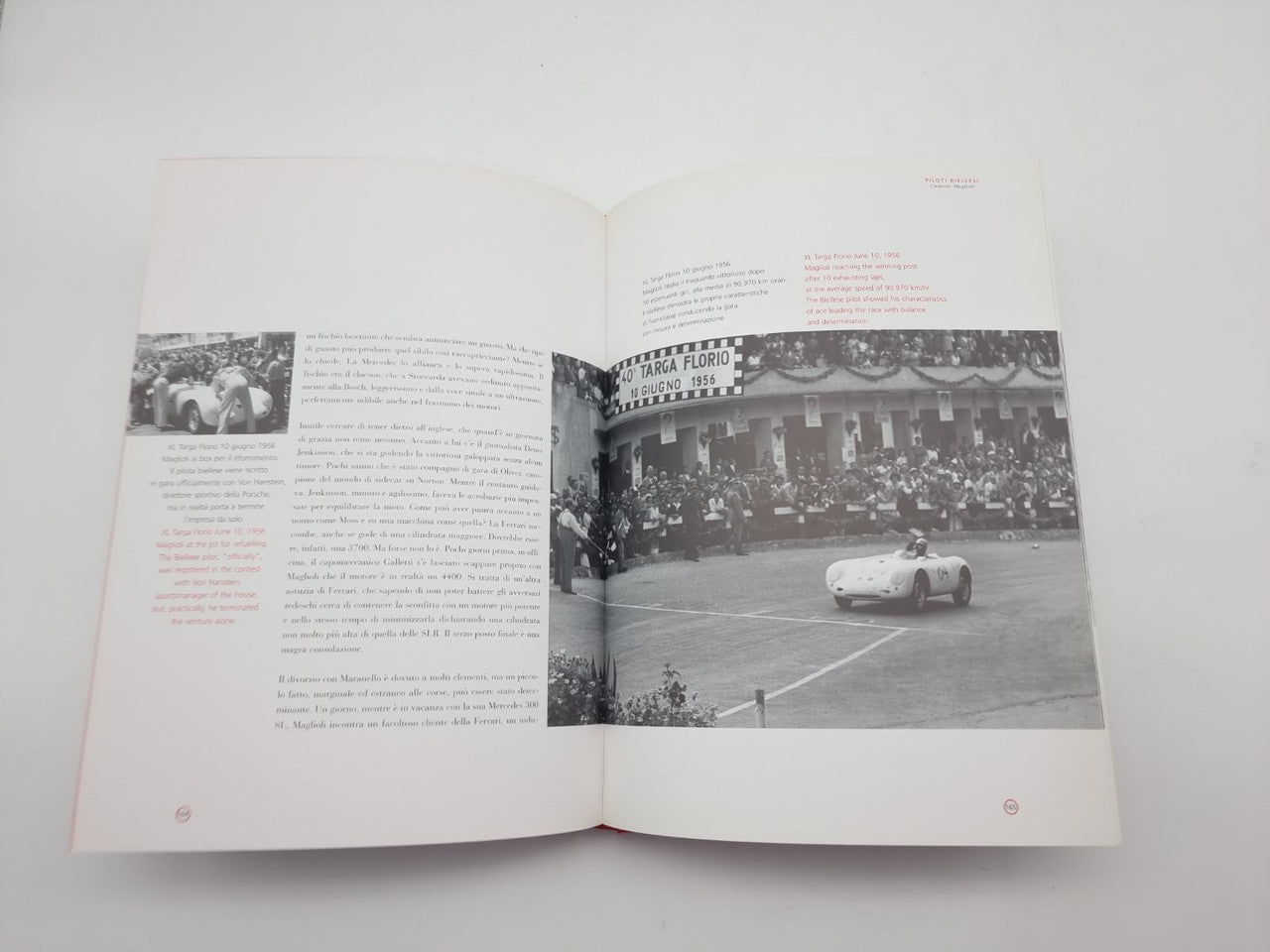 Open white book with printed text and black-and-white race photo pages