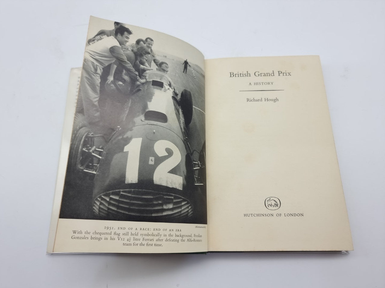 Open hardcover book showing black-and-white racing photo and title text