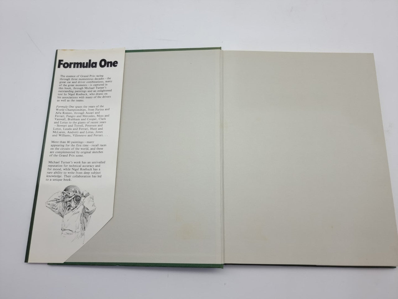 Open Formula One art book showing left page text and blank right page