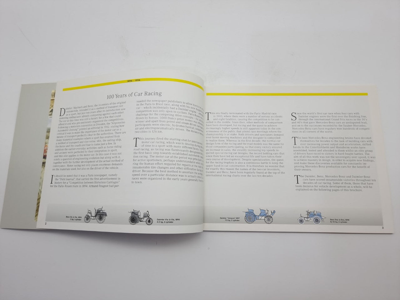 Motorsport history book open spread with yellow headings and vintage car silhouette diagrams.