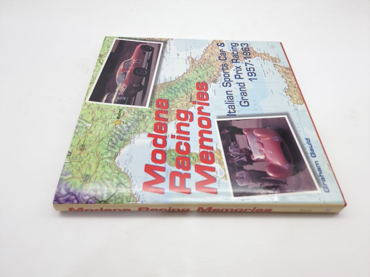 Motorsport history book angled view with racing photos and large title on the cover