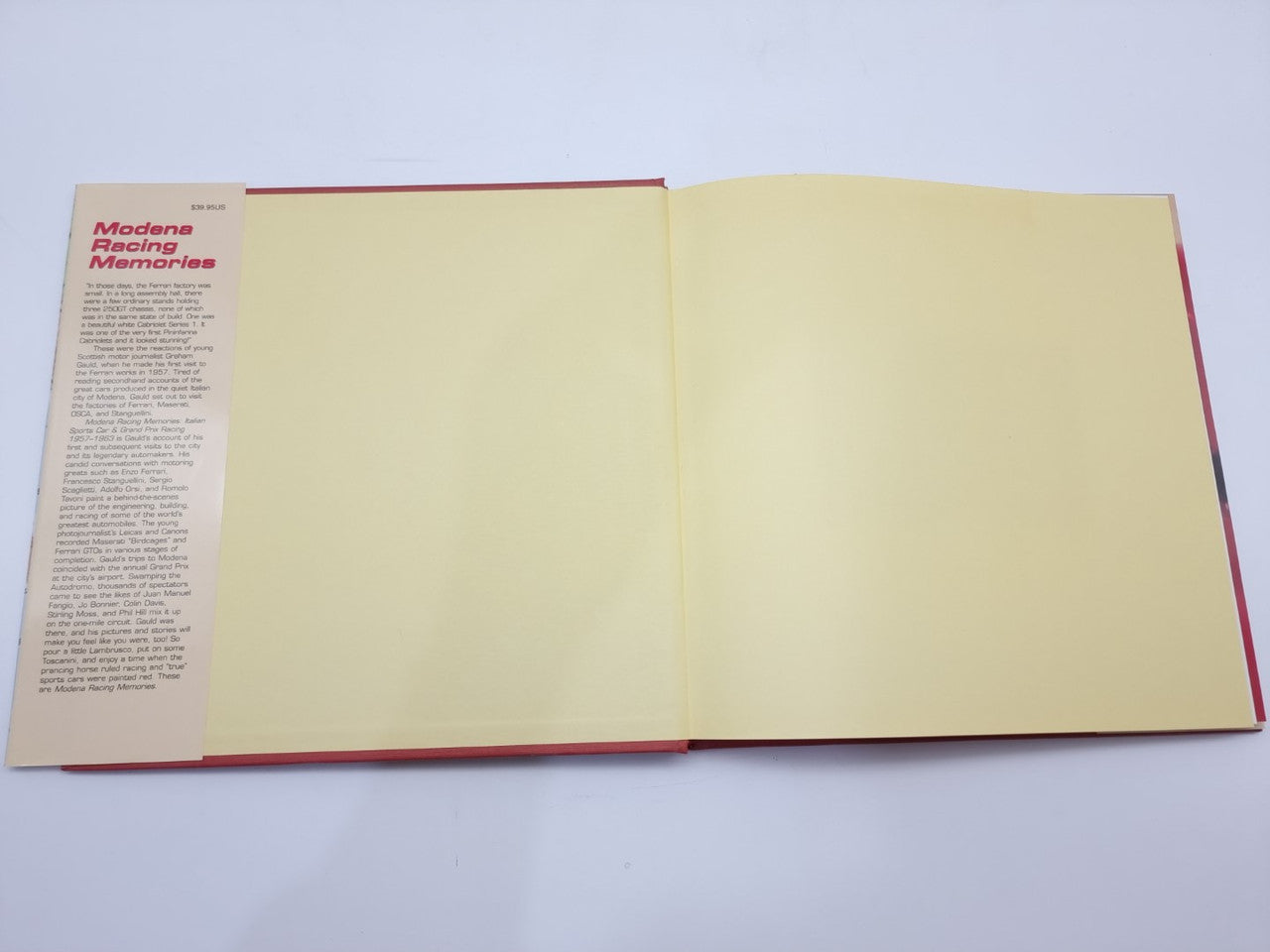 Open book showing blank cream pages and red-edged spine