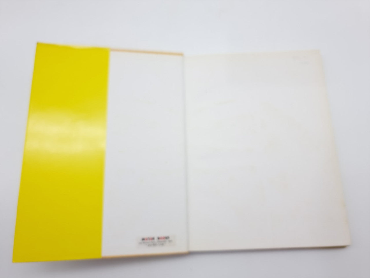 Open hardcover book with white pages and bright yellow paper edges