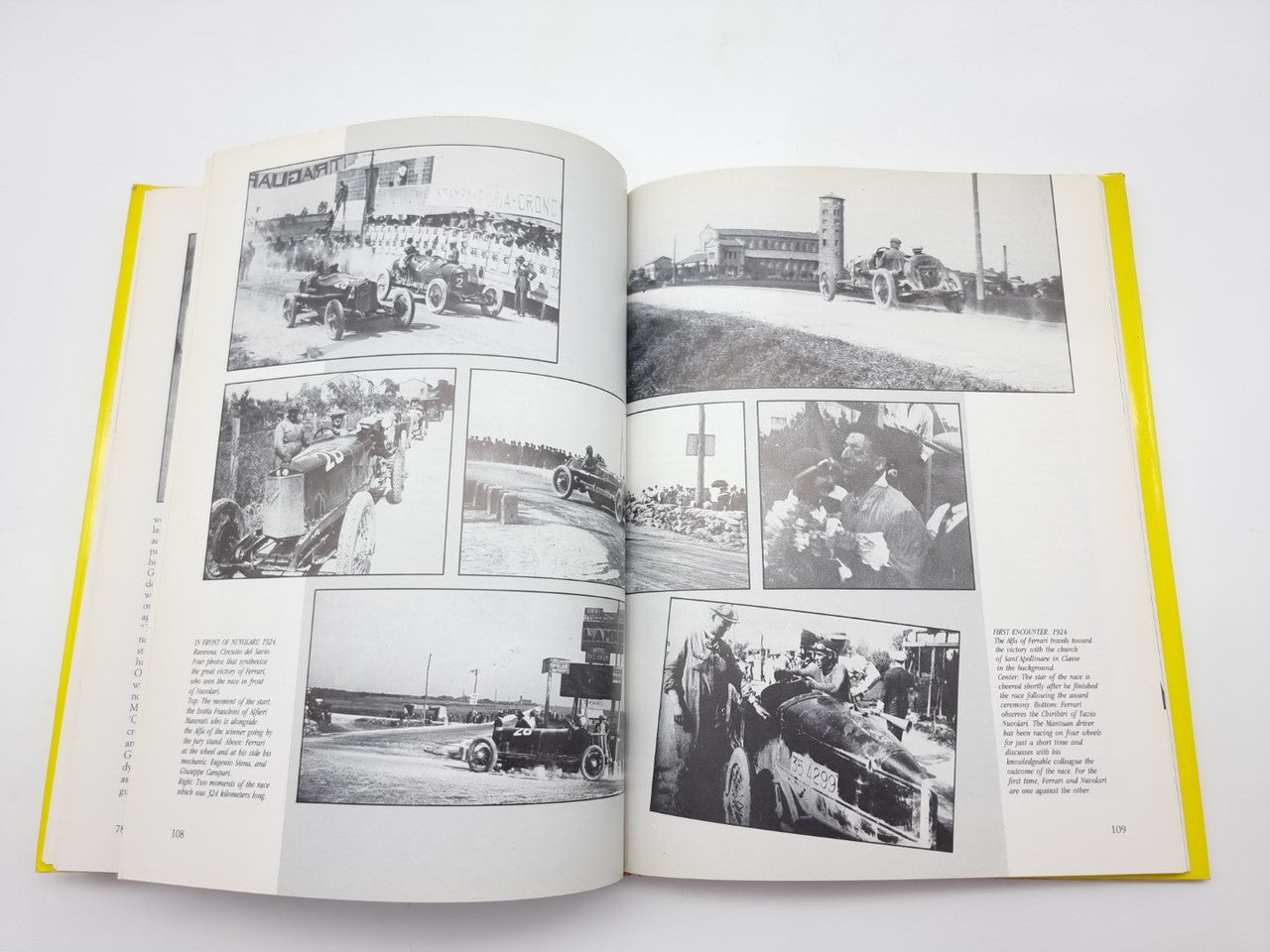 Open race history book spread with multiple black-and-white racing photos and paragraphs