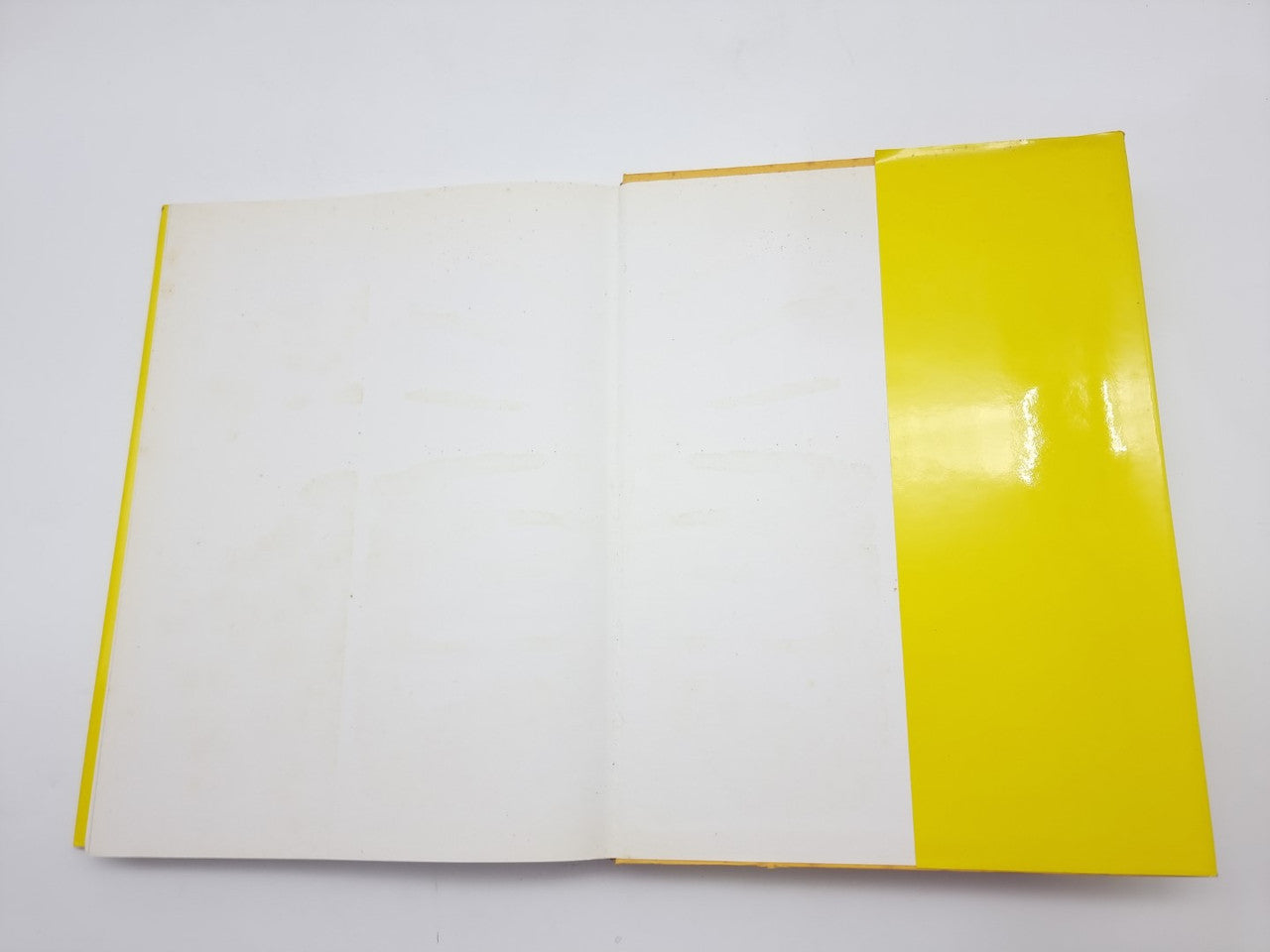 Open hardcover book with a bright yellow spine and matching yellow side edges