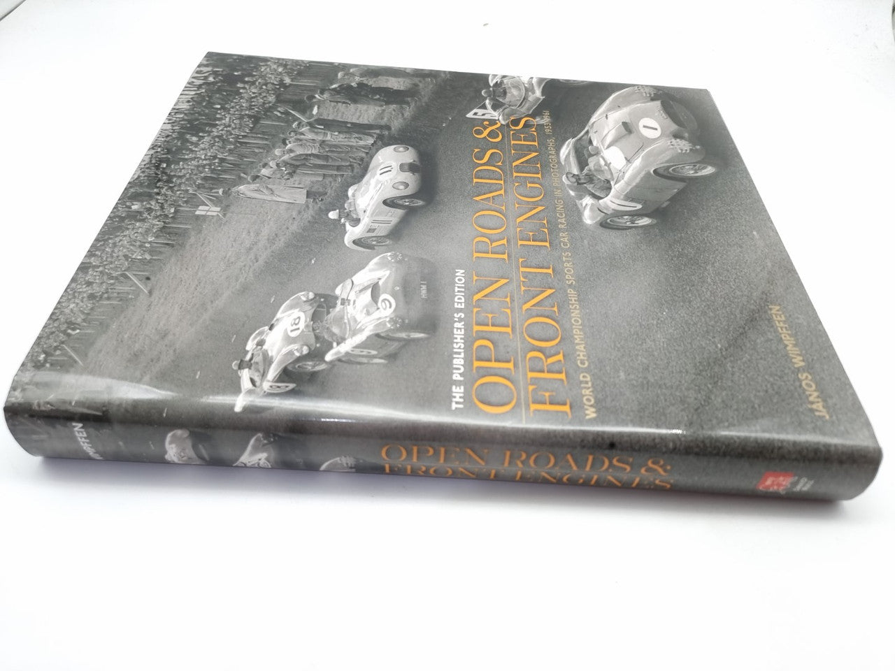 Signed hardcover book with angled photo cover featuring racing cars and title text