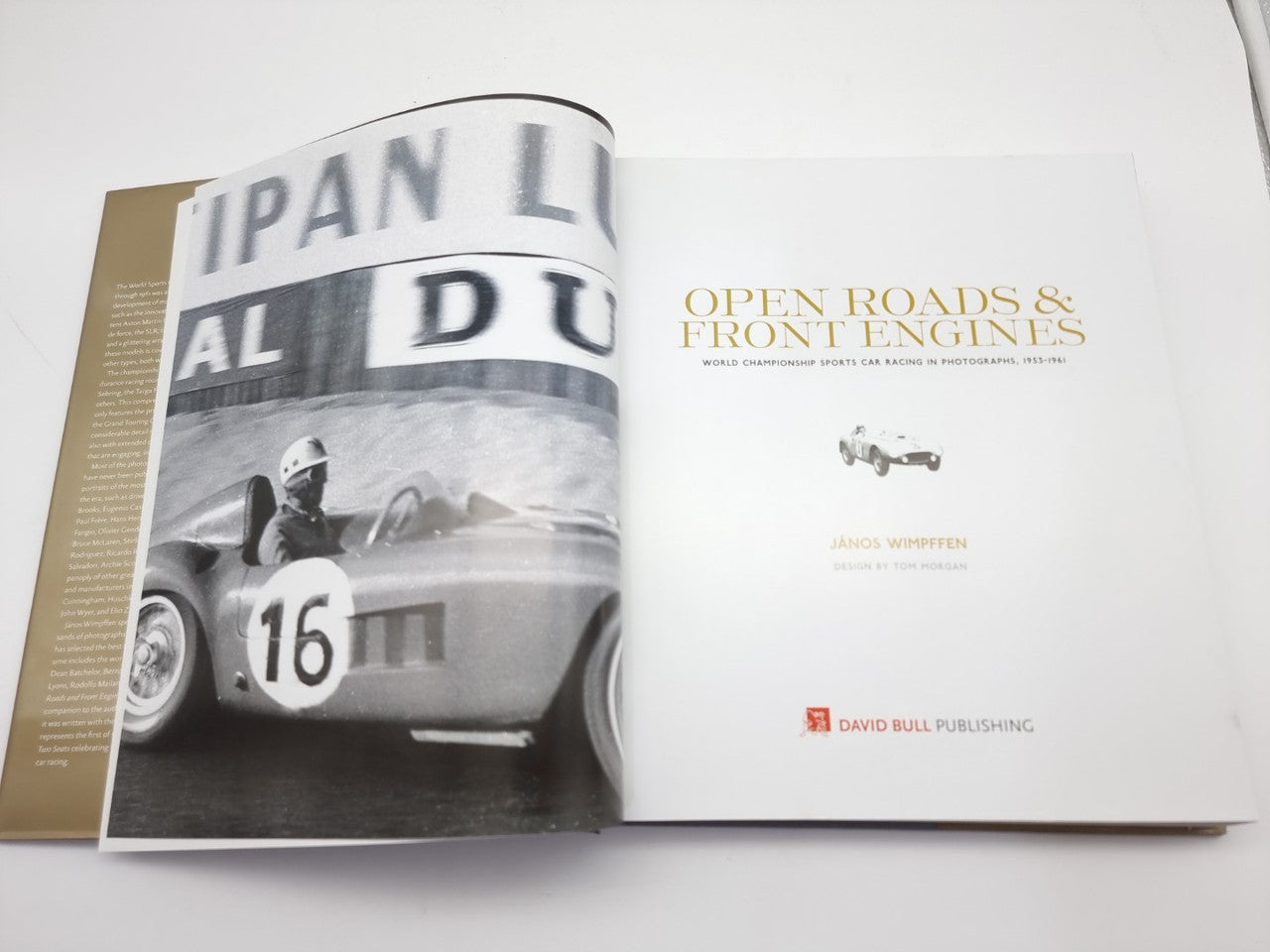 Open hardcover book with racing car photo cover on left and title page on right