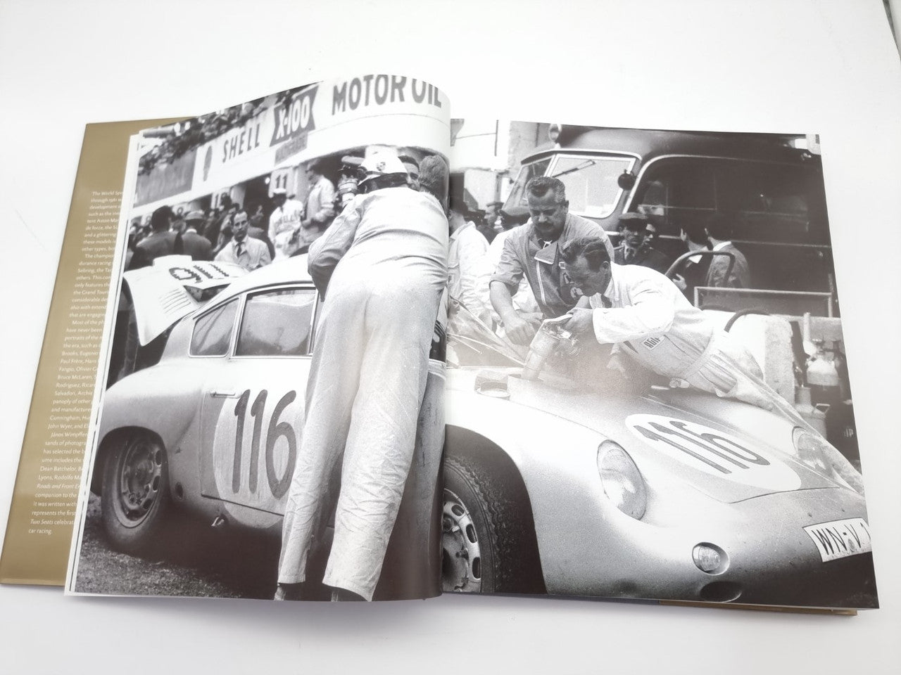 Opened hardcover book spread with black-and-white racing cars and numbered vehicles