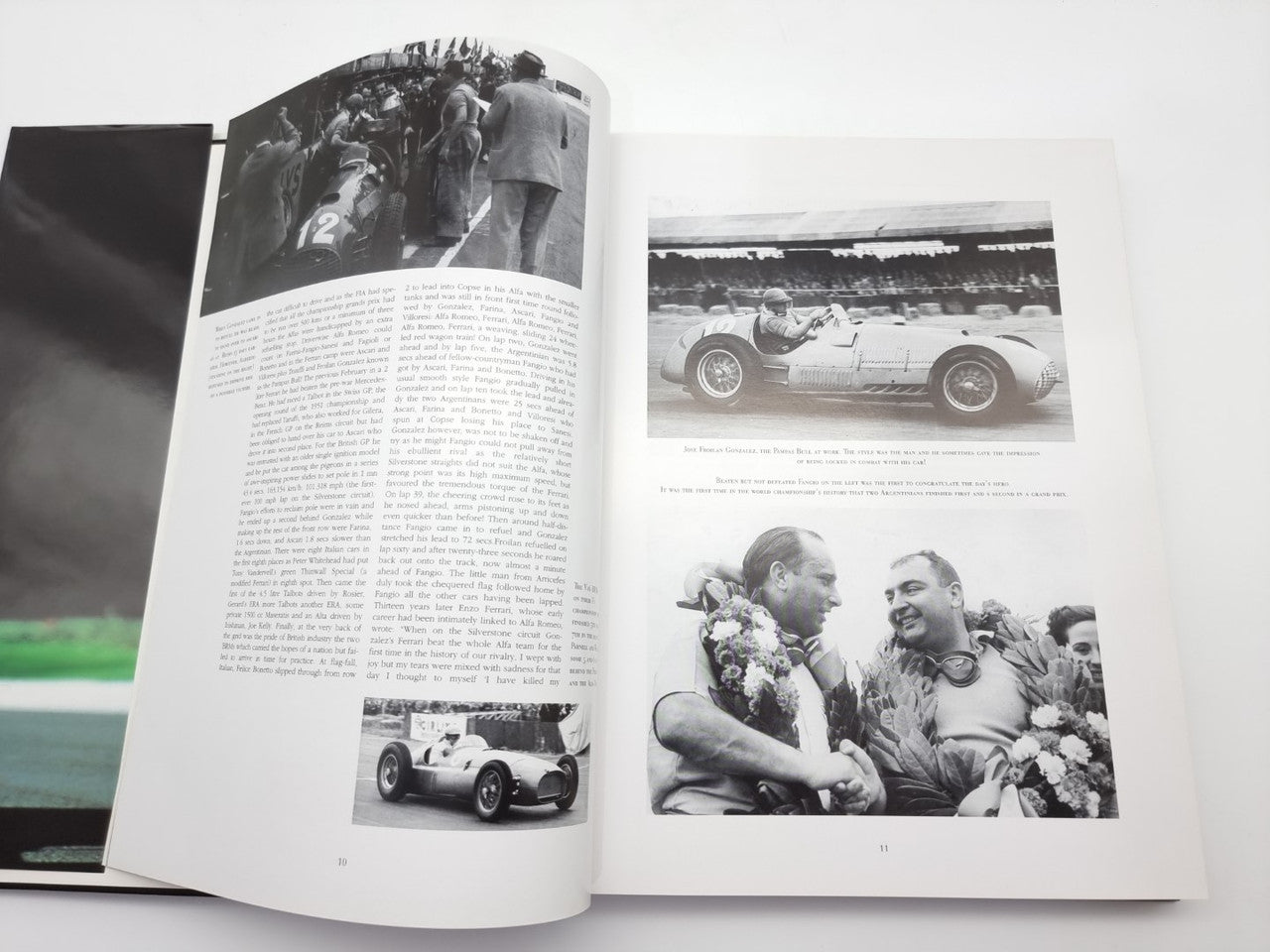 Open motorsport book with black-and-white race photos and caption text pages