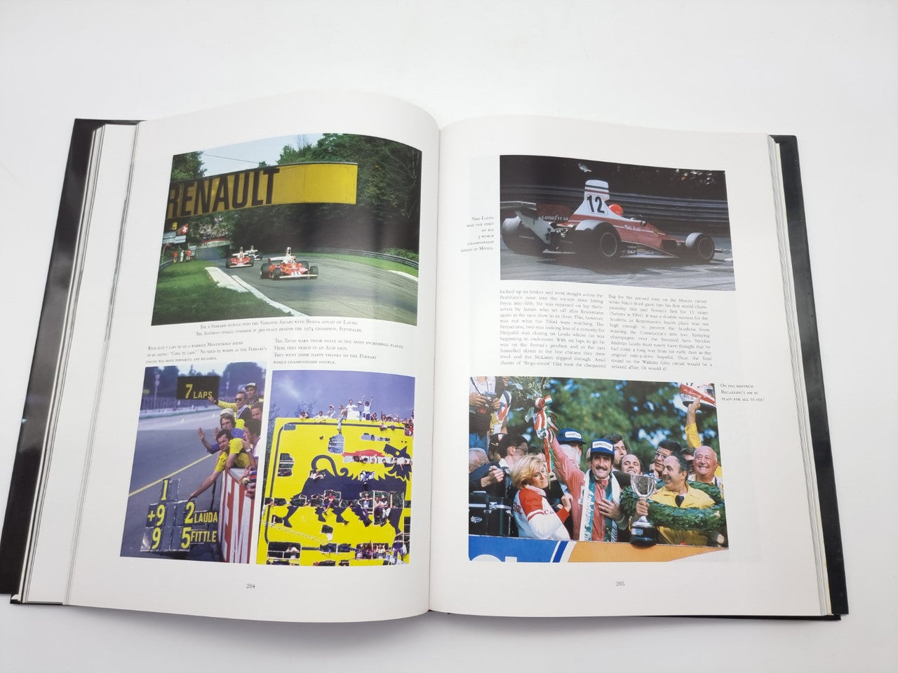 Open motorsport book with color race images and podium scene photos