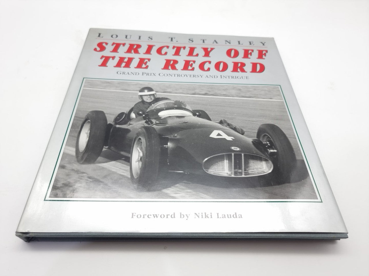 Racing history book with vintage formula car on front cover