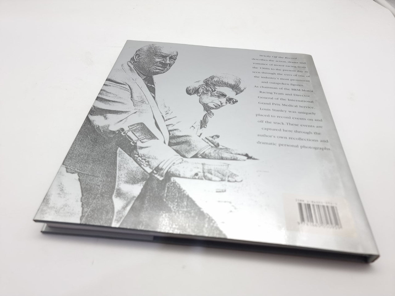 Racing history book open to a printed photo and text page on reverse side