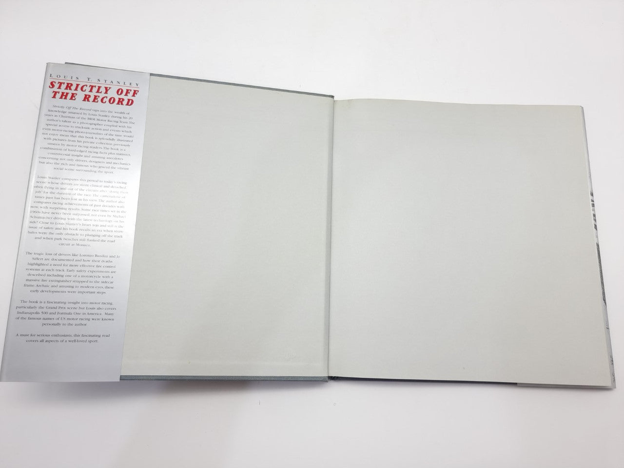 Racing history book open with blank interior pages and a left text page
