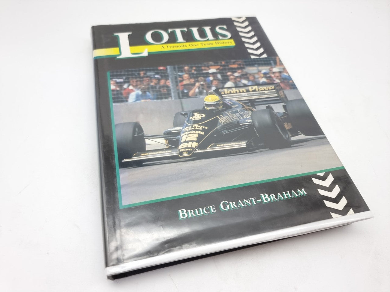 Motorsport history book with Lotus logo and black cover, featuring race car photo