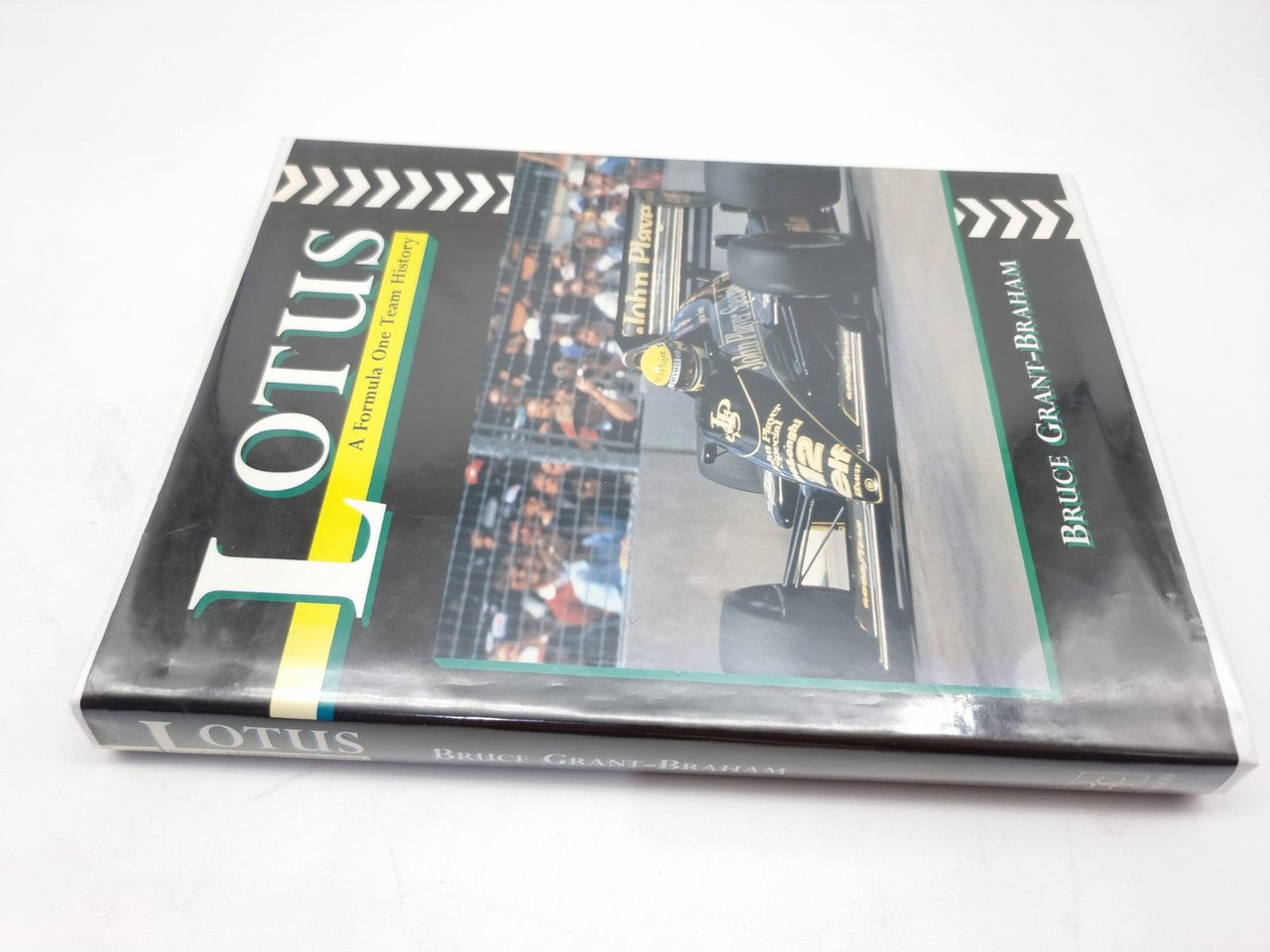Motorsport history book open cover with Lotus branding and race car photo