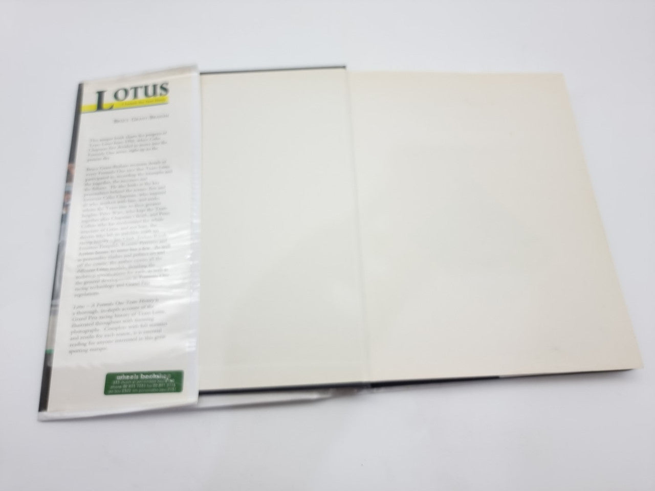 Motorsport history book open showing blank cream inside pages
