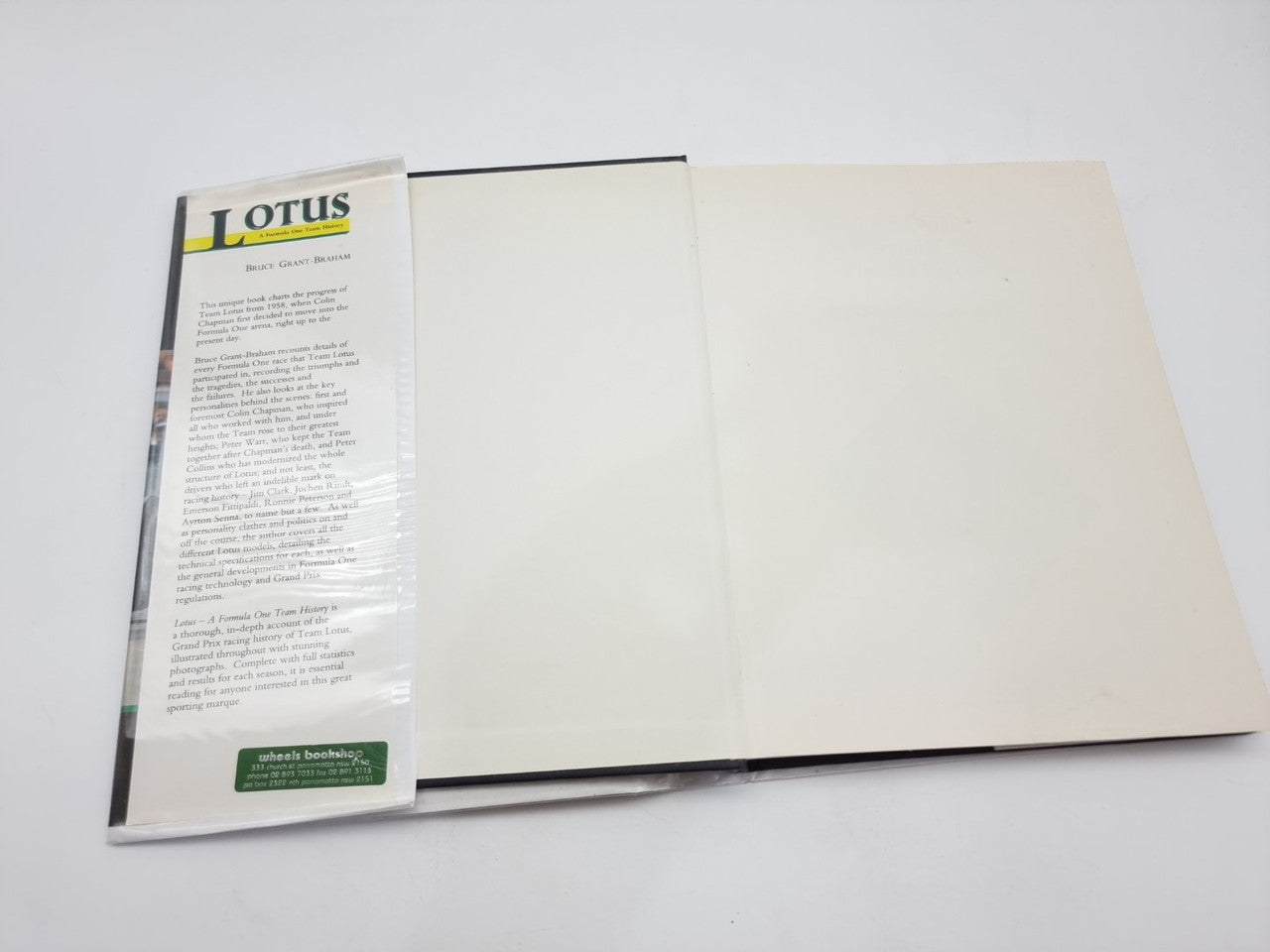 Motorsport history book open with white inside pages and left content column