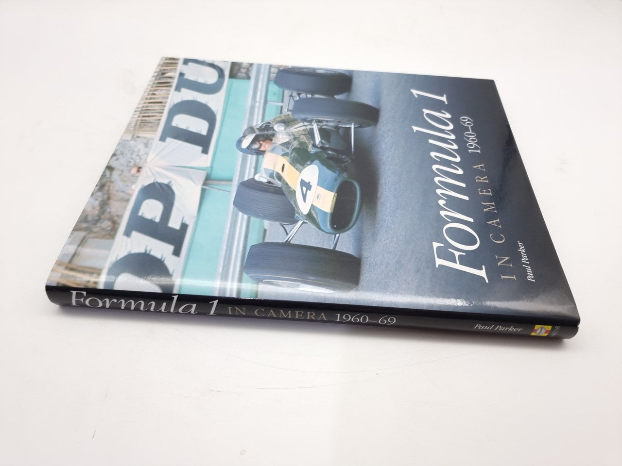 Motorsport photo book on its side, showing “Formula 1” and camera-themed cover art