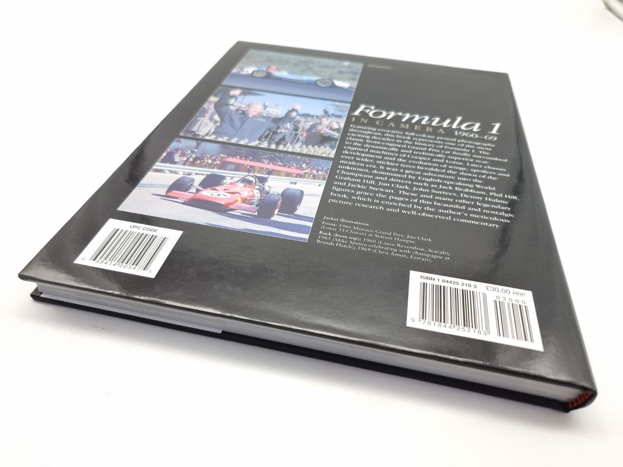 Motorsport photo book, black cover with race car image, barcode, and text block