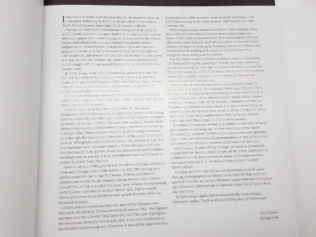 Photo book open to dense paragraph pages with small captions near the bottom