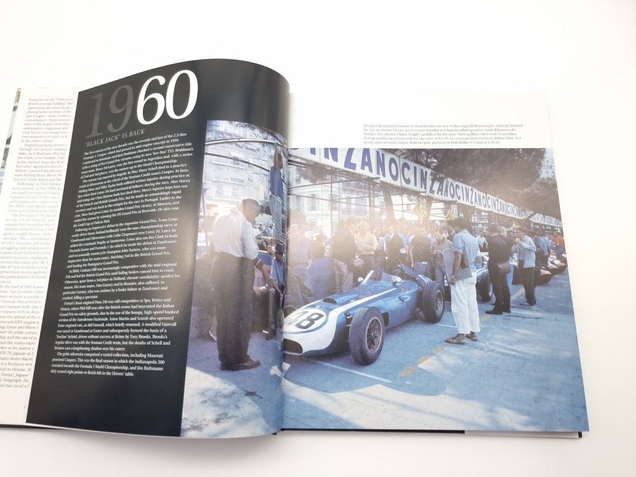 Photo book spread with dark left page and color race photo on the right