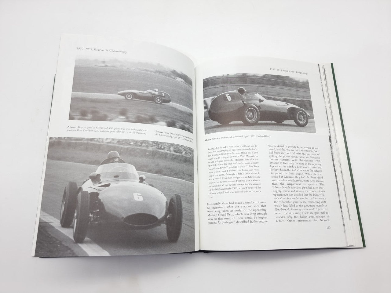 Open motorsport book with black-and-white race car photos and detailed text