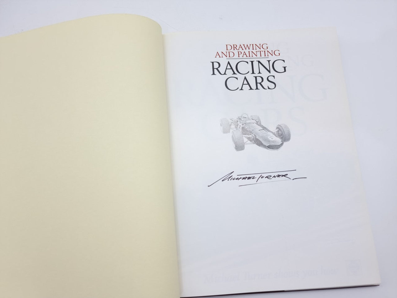 Racing cars drawing and painting book open to title page with silver car sketch