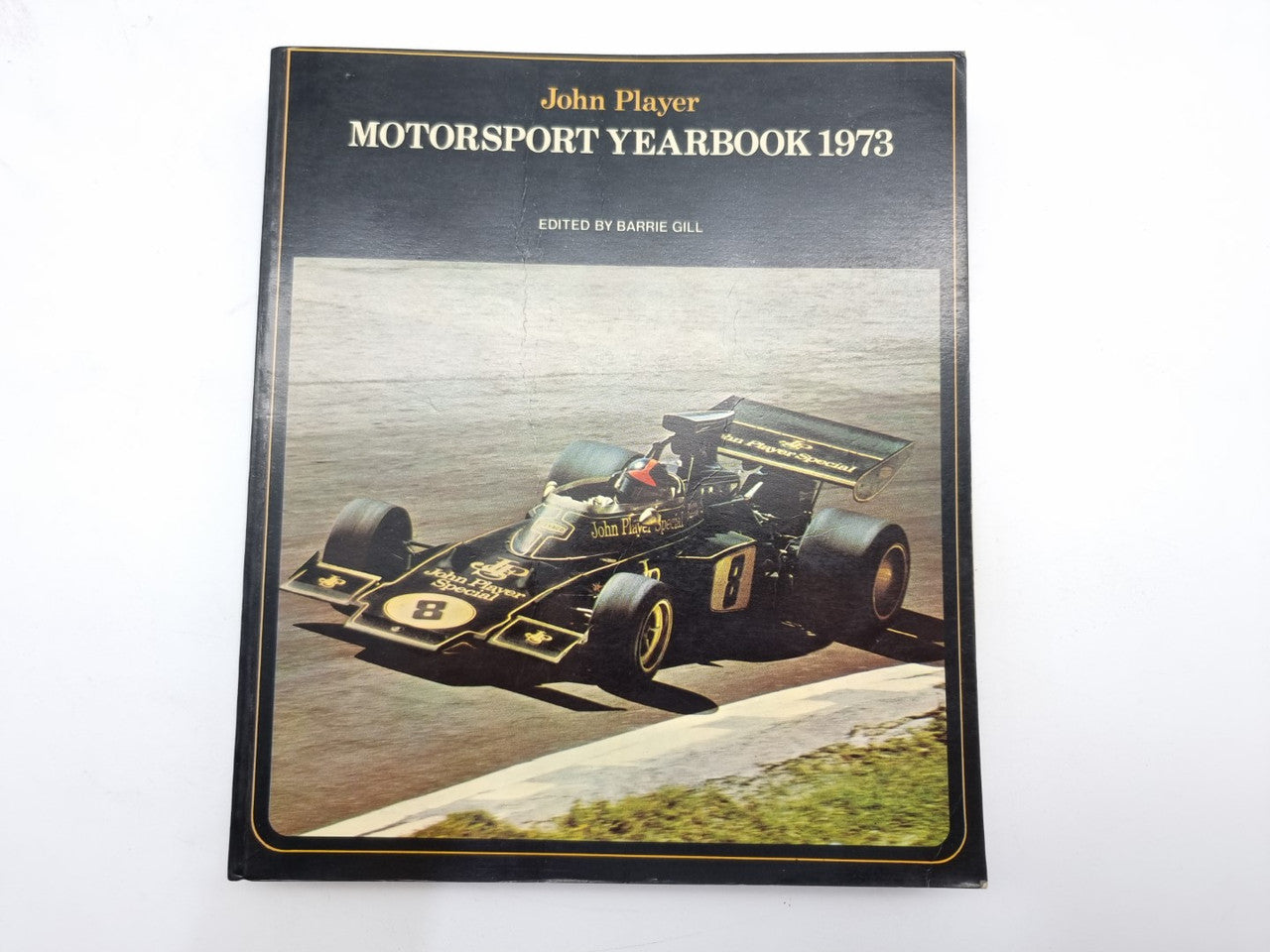 Motorsport yearbook 1973 cover featuring Formula racing car on road.