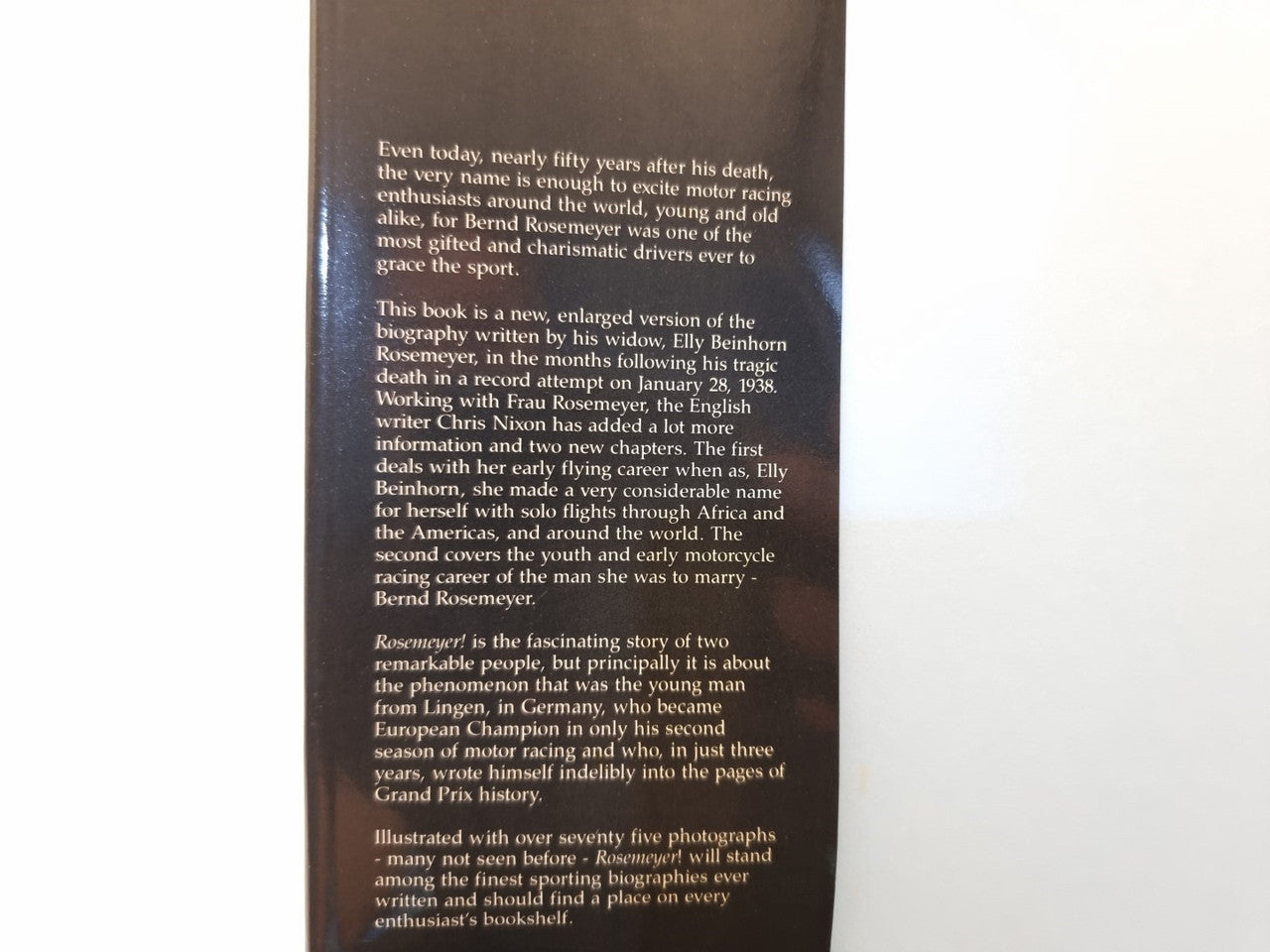 Biography book page with dense paragraphs of printed text, close-up