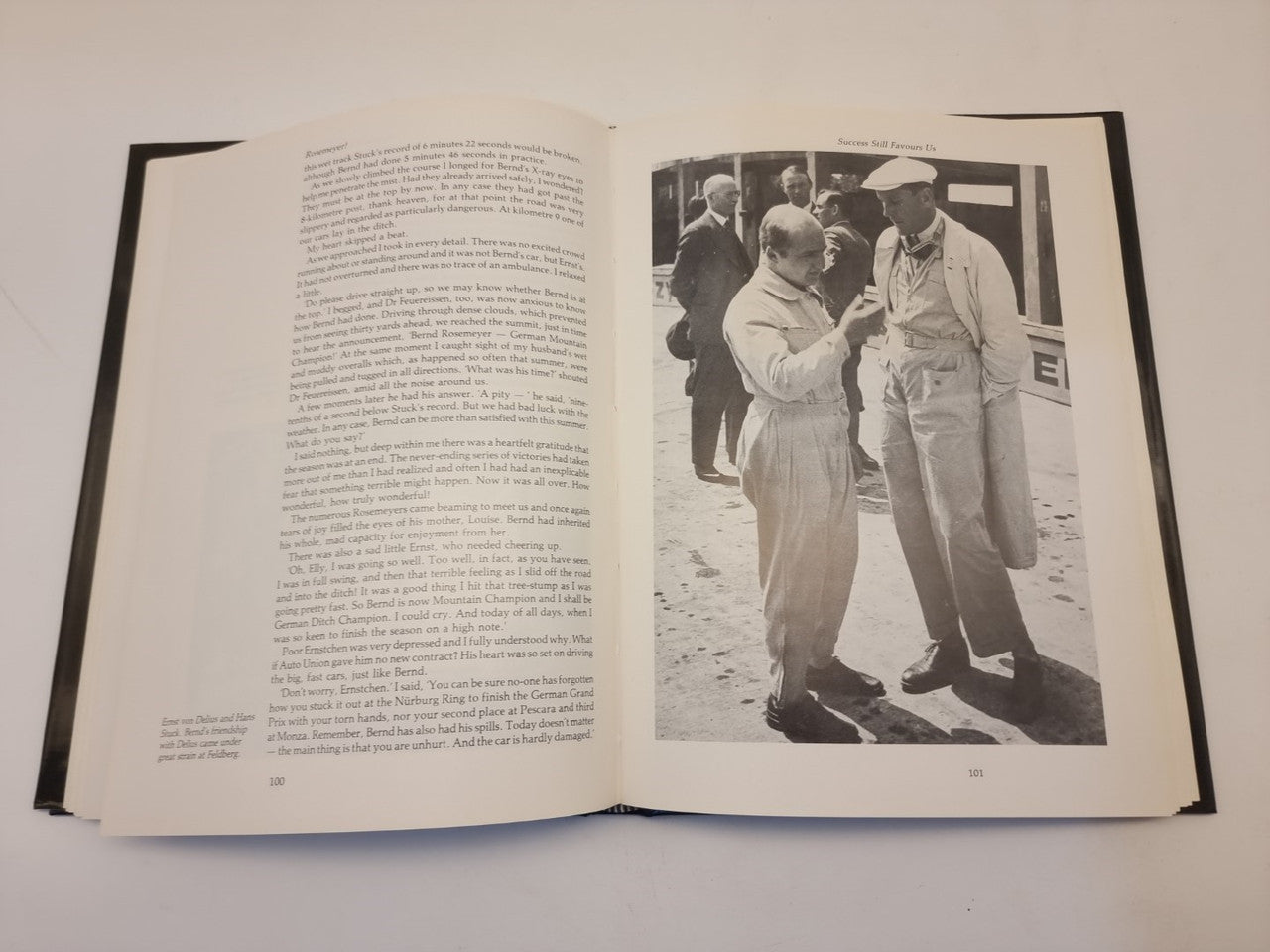 Open biography book with dense text and a black-and-white photo on the right