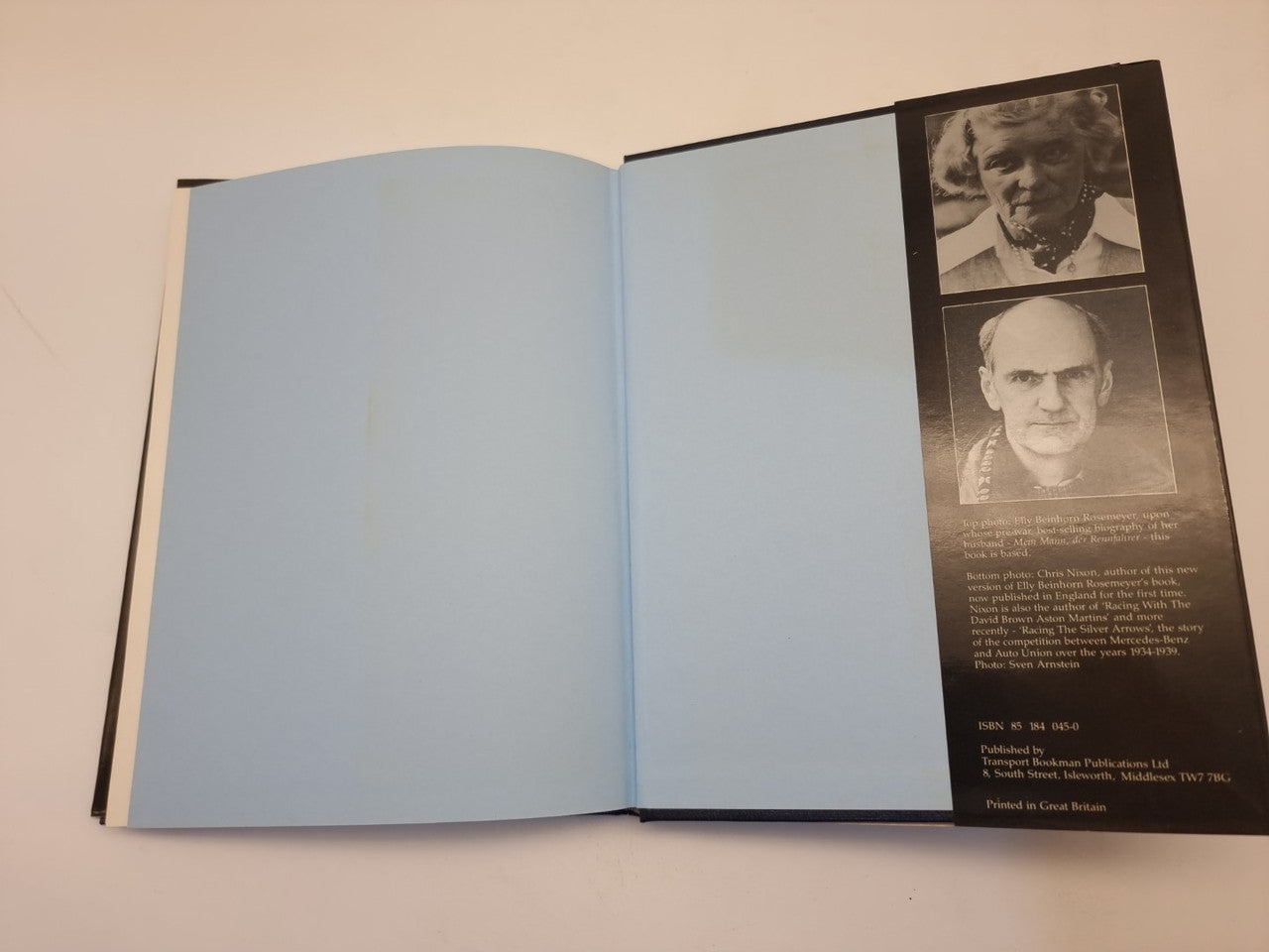 Open biography book with empty left pages and author photo panel on the right