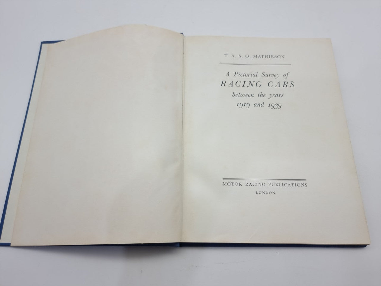 Open book with blank left page and racing cars title page on right