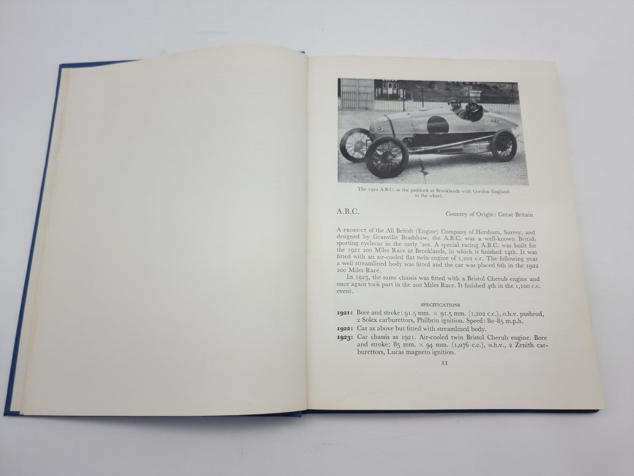 Open book spread with a small black-and-white race car photo on right page