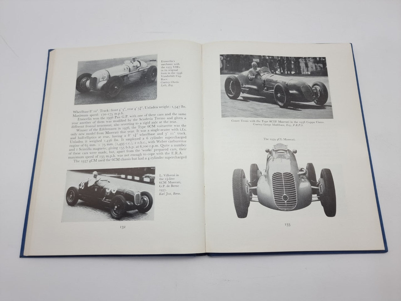 Open racing cars history book with large front car photo and track car photo