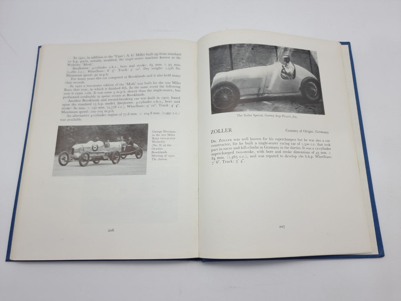Open racing cars history book with vintage car photo and driver close-up