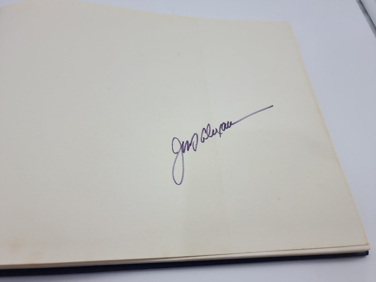 Signed book page with handwritten autograph