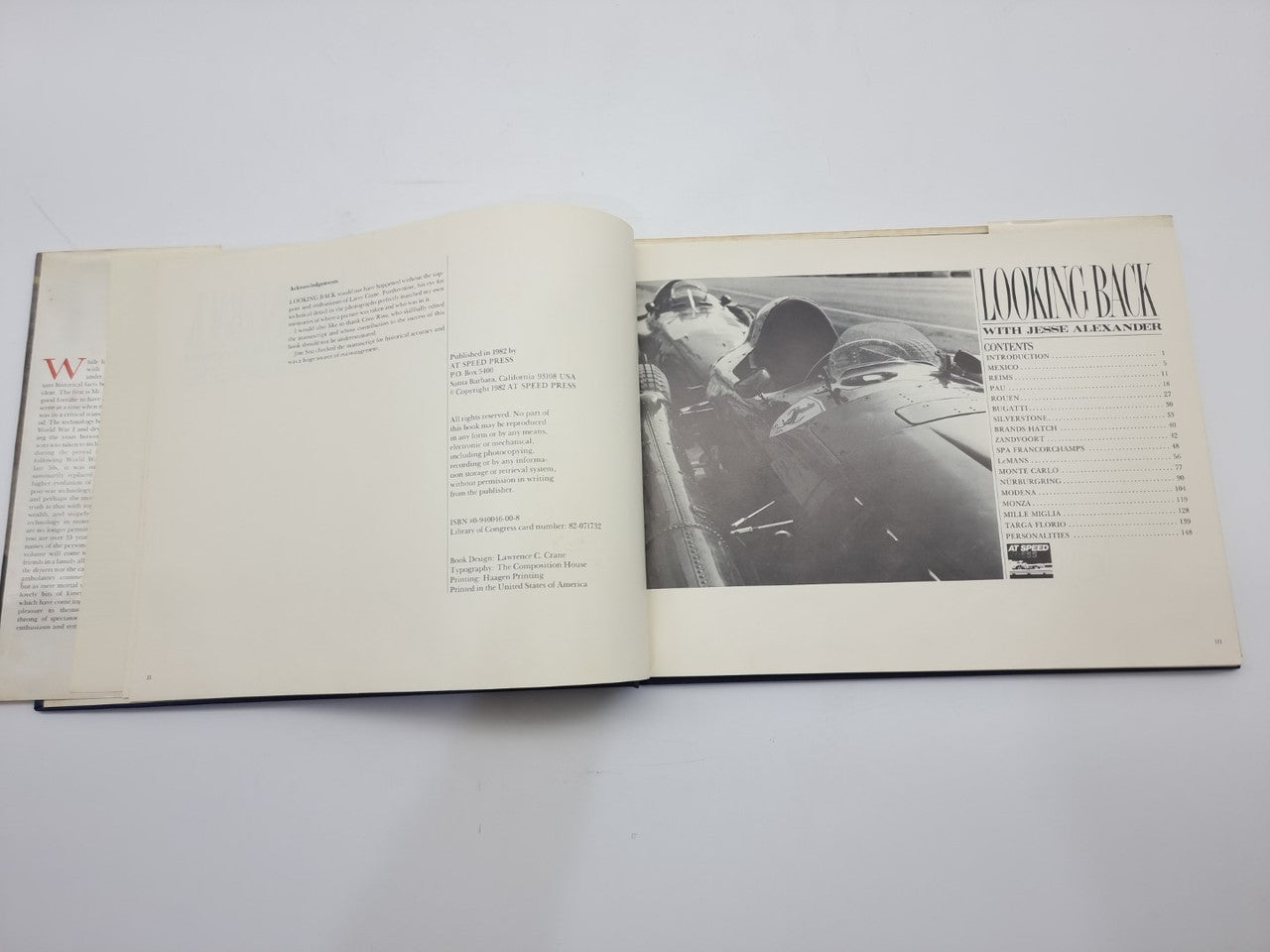 Open book spread with text columns and black-and-white car race photo